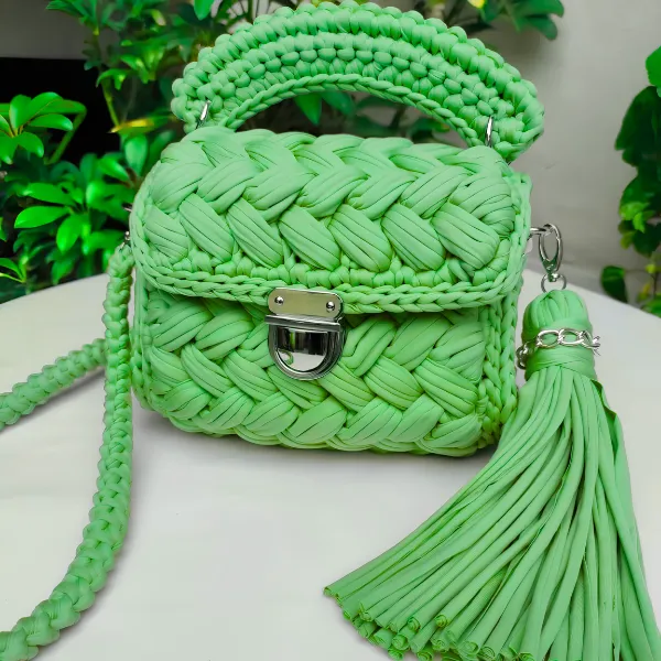 Bolso puff verde con tejido trenzado y borla